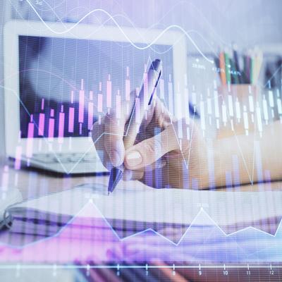 Businesswoman writing notes illustrated with finance, forex charts graphics.