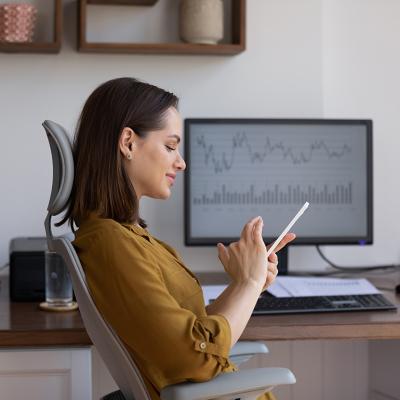 A female finance trader using her smartphone at work.