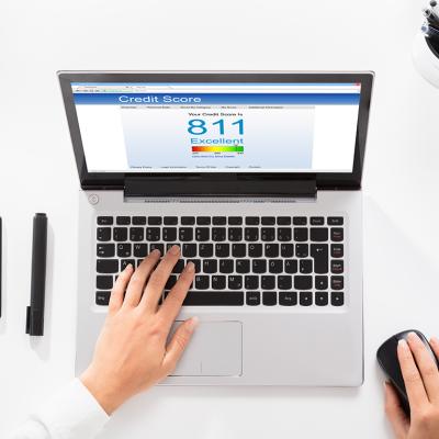 An office table with a laptop showing credit score.