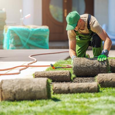 A lawn care professional installing new grass at a home.