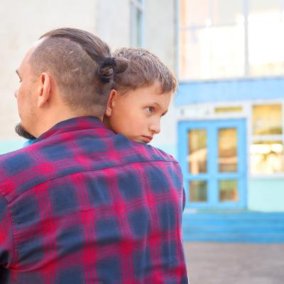 A father hugs his young son before leaving for school.