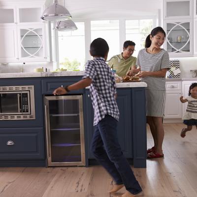 Parents prepare food as their children play around the kitchen.
