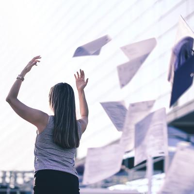 Businesswoman throws paper in the air.
