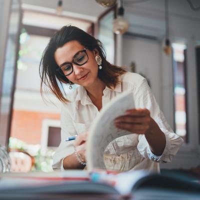 A freelance female designer browsing her design book in a studio.
