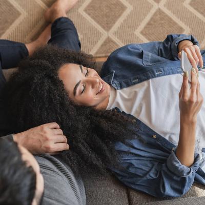 Young couple at home browsing information using a phone.