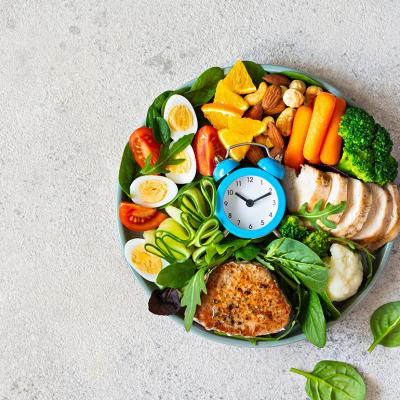 A bowl of vegetable meat with meat, fish, eggs, and a clock at the middle.
