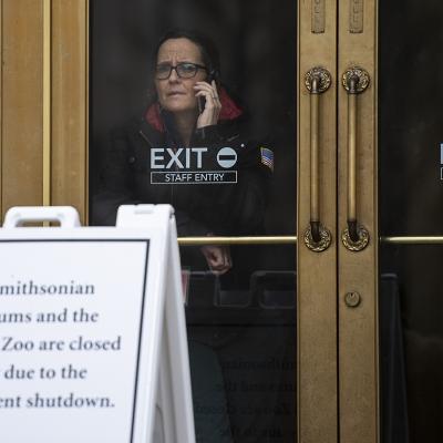 A US government employee talks on the phone as she looks out of a closed Smithsonian museum in Washington, DC on January 18, 2019, where the government has been shut down for four weeks.