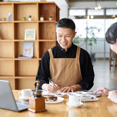 A cafe small business owner calculating costs of products.