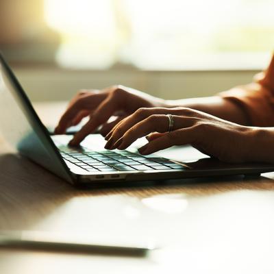 Freelancer typing on a laptop keyboard.