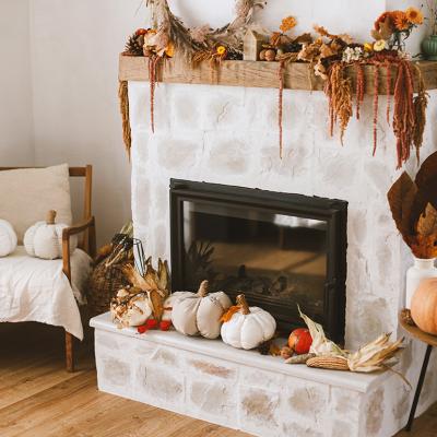 Fireplace corner of a living room with fall season decoration.