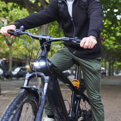 Man riding electric bicycle on a street.