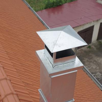Aerial view of metal pipe chimney with cap on a Spanish tile roof.                          