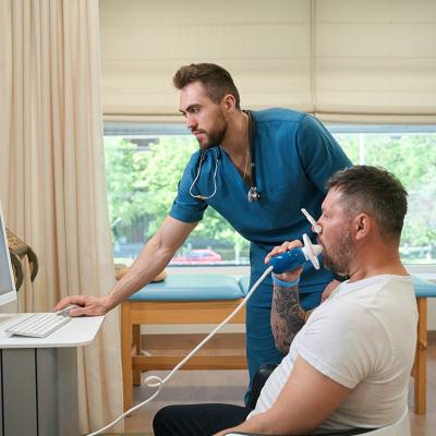 A pulmonologist checking a patient's lung functions during a spirometry test.