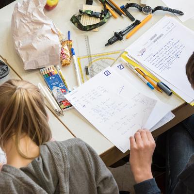A pair of mathematics students writing on paper during the finals of a math competition.