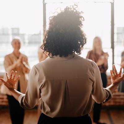A woman in front of her colleagues leading a talk in the workplace.