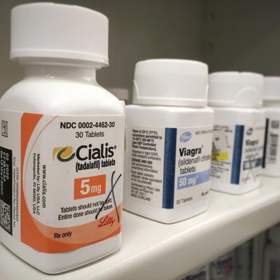 Bottles of Cialis and Viagra on a shelf.