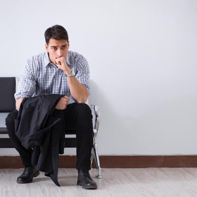 A man sits nervously waiting in a lobby.