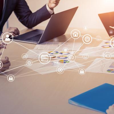 Business people in a meeting with an overlay of networking and communication icons.