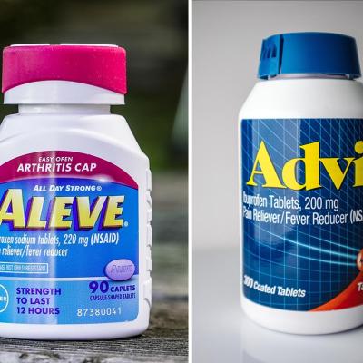 Composite image of a bottle of Aleve with a pink cap on an outdoor table and a bottle of Advil with a blue cap on a white surface.