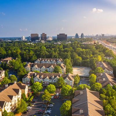 Condos in Atlanta suburbs just next to Highway GA 400 with blue sky and downtown in background.