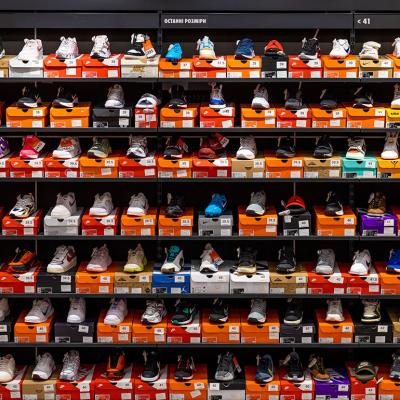Various styles and models of Nike shoes neatly displayed on store shelves.