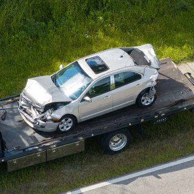 A damaged car loaded on a tow truck from the accident site.