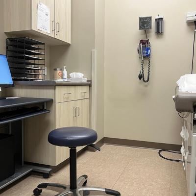 An empty examination room in a clinic with a computer, exam tamble, stool and various medical devices on the wall in Muscle Shoals, Alabama USA.