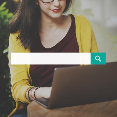 A search bar over a background of a woman using a laptop.