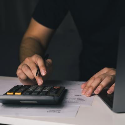 A man uses a calculator to compute monthly expenses.