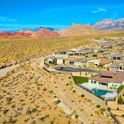 An aerial view of a modern suburban residential neighborhood situated in a mountainous desert area.