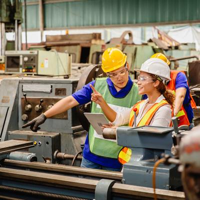 Heavy industry machine workers coordinating on site.
