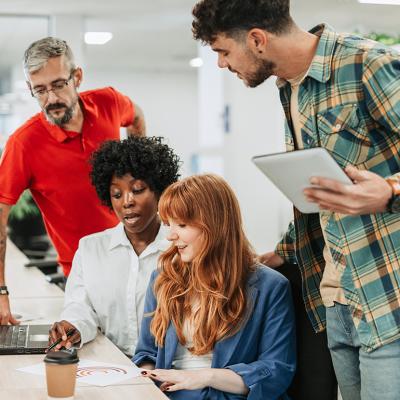 A diverse four-member team sharing ideas in an office.