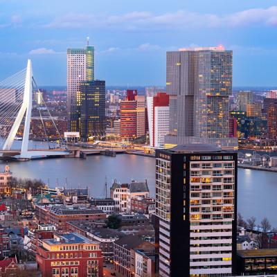View of the Rotterdam city skyline over the Nieuwe Maas River during twilight in Netherlands.