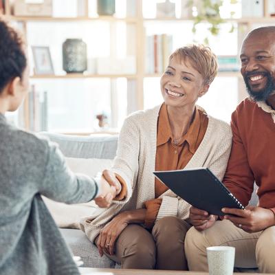A couple shaking hands with a financial advisor.