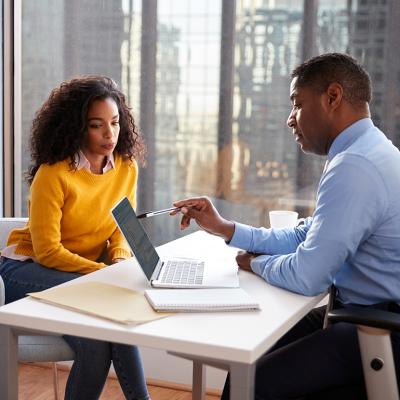 A young woman engaged in a discussion with a financial advisor in an office.