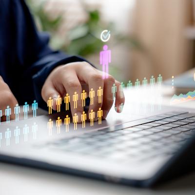 Concept of HR recruitment showing digital human figures illustrated over a businessperson using a laptop.