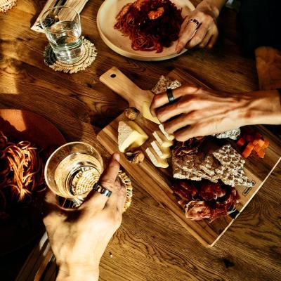 Top view of ptwo people having a Thanksgiving charcuterie board and drinks. They are wearing Oura rings.