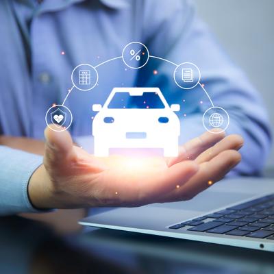 A car insurance agent using a laptop with graphics of car insurance concepts illustrated over his hand.
