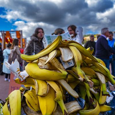 A pile of banana peels in the trash during a marathon in a city.