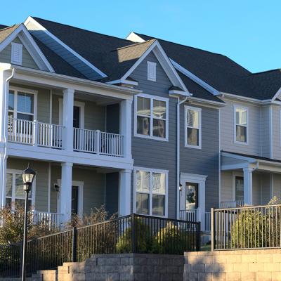 A row of townhouses with grey and white exterior in a housing community.