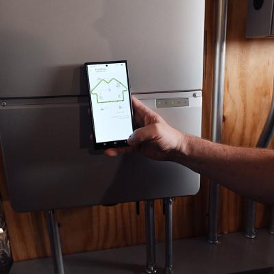 A homeowner using a phone monitoring a battery from Sunrun, a company which provides home solar and batteries. A new partnership between Sunrun, Ford and the Baltimore Gas and Electric Company has resulted in a residential vehicle to grid pilot project.