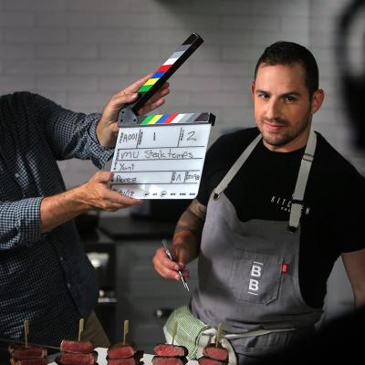 Yankel Polak, ButcherBox head chef, smiles while director and cinematographer Scot Yount snaps a slate at ButcherBox in Peabody, MA on Aug. 22, 2018. ButcherBox is a subscription based service for grass-fed beef - as well as humanely-raised pork and chicken.