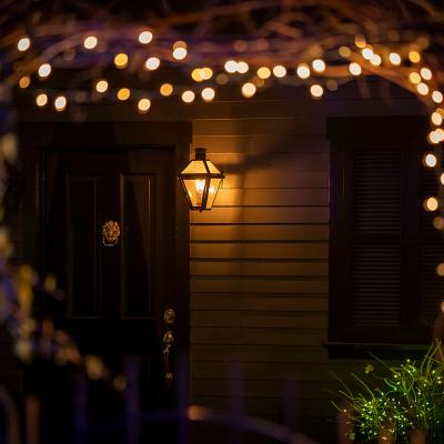 Holiday lights during night designed around an arch leading to a house's doorway.