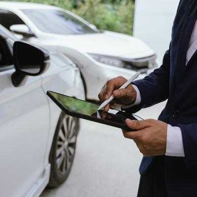 A car insurance agent inspects a damaged vehicle.