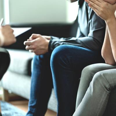 A couple sitting on a sofa during a marriage counseling session.