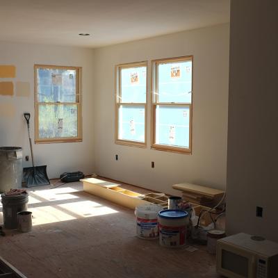 Paint samples on a wall of a sun-lit room with remodeling in progress.