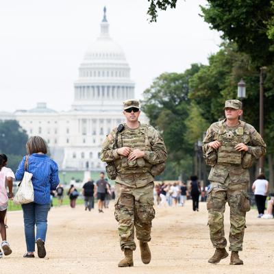 Members of the National Guard walking among civilians as part of their patrolling near the US Capitol area in Washington, DC.
