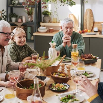 A group of senior people talking to each other at the dinner table.