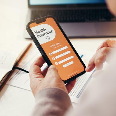 A senior person browsing a health insurance app on a smartphone.