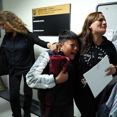 A wife and her children crying as her husband is detained by federal agents outside a New York Federal Plaza Immigration Court room in New York City.